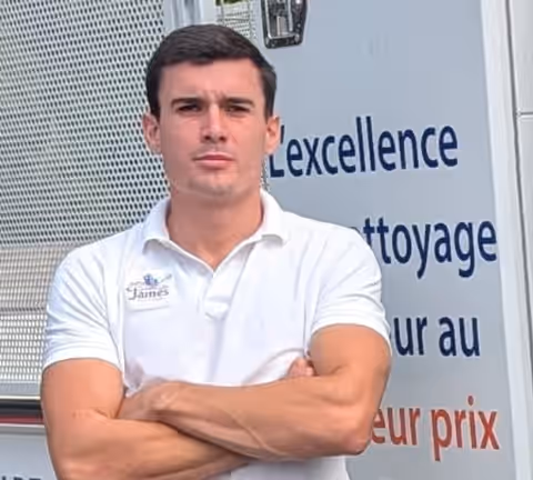 James Dorkel, bras croisés devant le camion de James Eco Clean, polo blanc au logo de l’entreprise