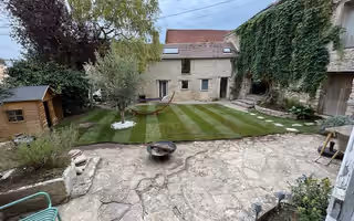 Une pelouse tondue en bandes dans une cour en pierre de pays des Yvelines